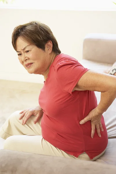 Mulher Sênior sofrendo de dor nas costas em casa — Fotografia de Stock
