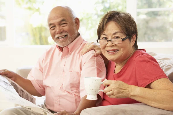 Seniorenpaar liest Zeitung zu Hause — Stockfoto