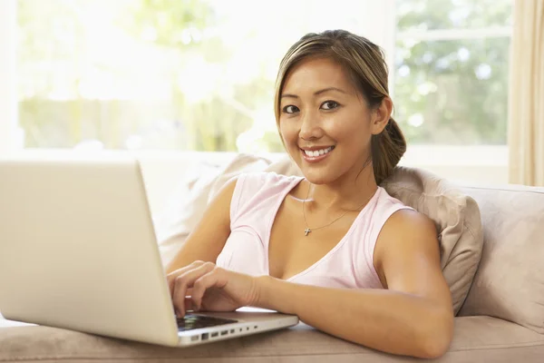 Giovane donna che utilizza il computer portatile a casa — Foto Stock
