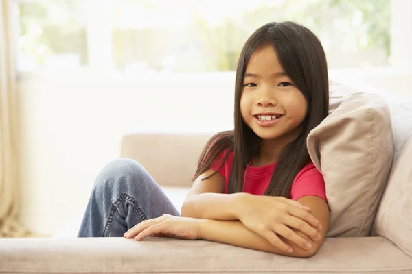 Молода дівчина розслабляється на дивані вдома — стокове фото
