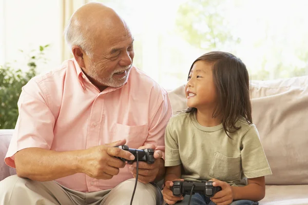 Farfar och barnbarn spelar datorspel hemma — Stockfoto