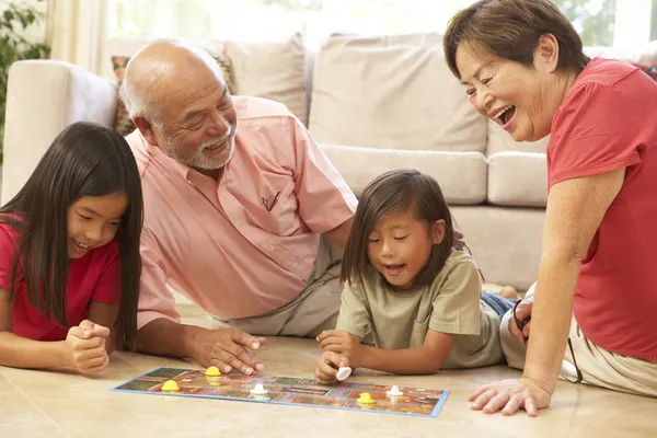 Nonni e nipoti gioco da tavolo a casa — Foto Stock