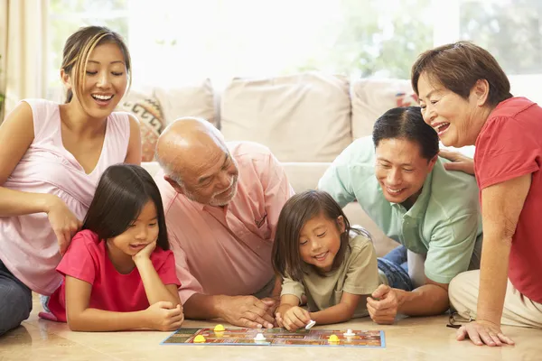 扩大的家庭组玩的棋盘游戏 在家里 — 图库照片