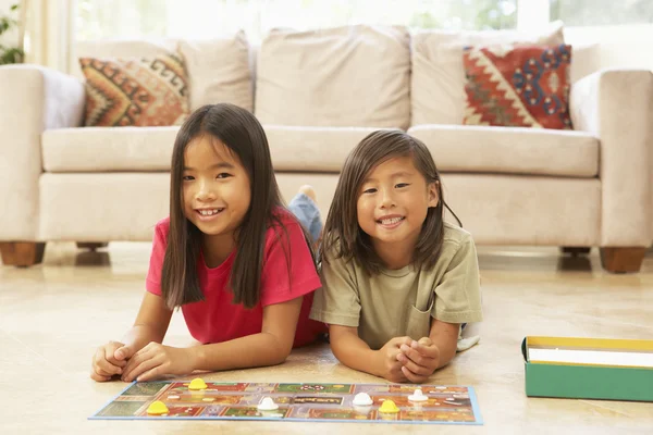 Två barn spelar brädspel hemma — Stockfoto