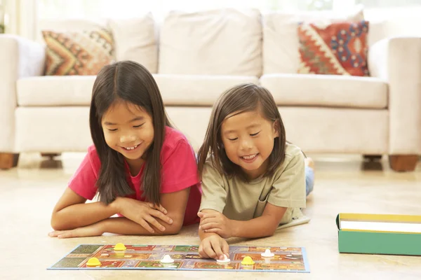 Duas crianças jogando jogo de tabuleiro em casa — Fotografia de Stock
