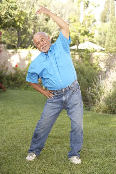 Uomo anziano che esercita in giardino — Foto Stock