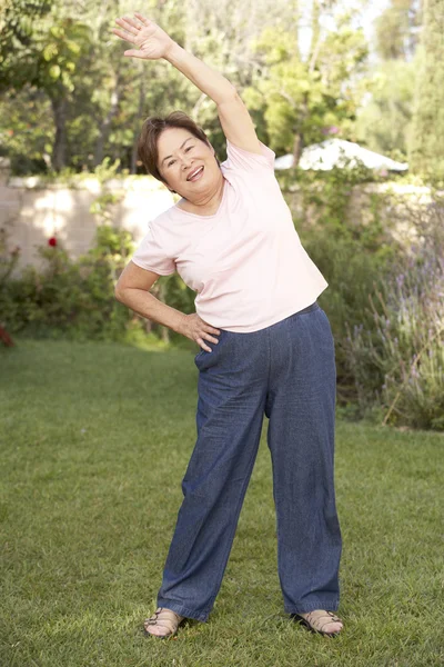 Mujer mayor haciendo ejercicio en el jardín —  Fotos de Stock