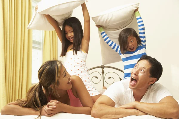 年轻家庭有枕头战在卧室里 — 图库照片