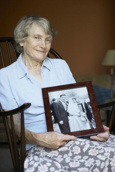 Senior Woman At Home Looking At Old Wedding Photo — Stock Photo, Image