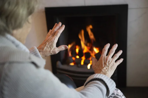Senior Vrouw Opwarming Van Aarde Handen Door Brand Thuis — Stockfoto