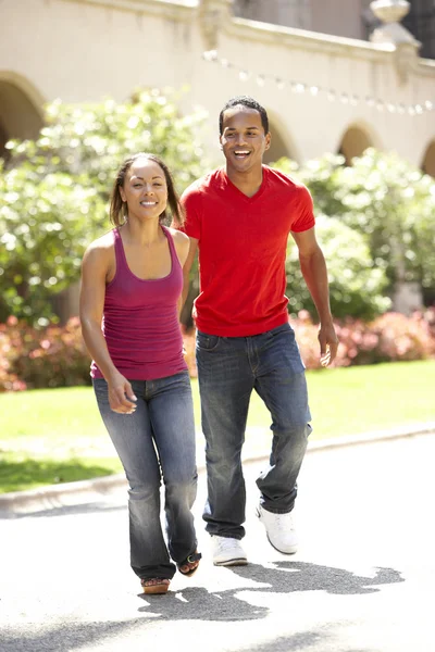 Молодая пара, идущая по городской улице — стоковое фото