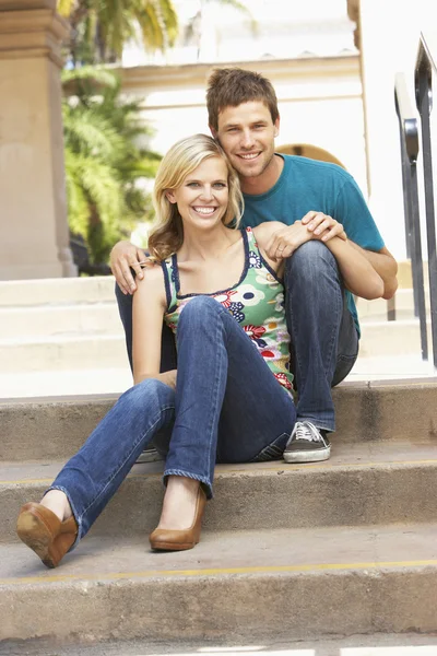 Молода пара сидить на сходах будівлі — стокове фото