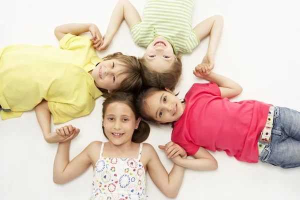 Circle of four young friends smiling and holding hands Stock Picture