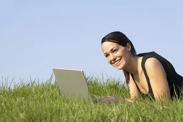 Frau nutzt Laptop im Freien in sommerlicher Landschaft lizenzfreie Stockfotos