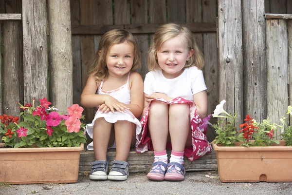 Two Young Girls Playing Wooden House Stock Photo