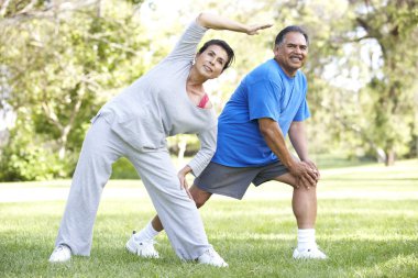 Senior Couple Exercising In Park clipart