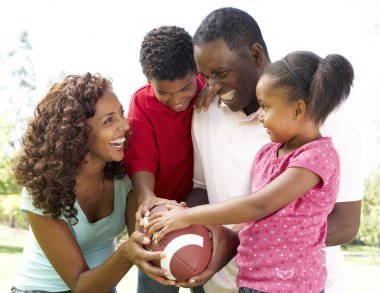 Family In Park With American Football clipart