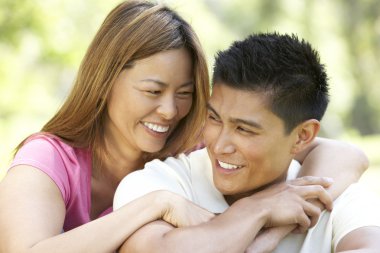 Portrait Of Young Couple Sitting In Park clipart