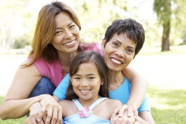 Grandmother With Daughter And Granddaughter In Park clipart