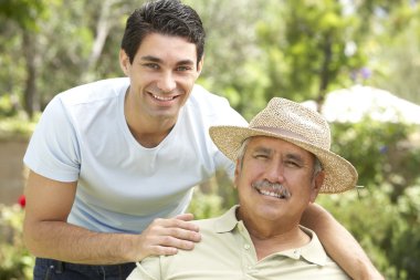 Senior Man With Adult Son In Garden clipart