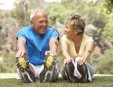 Senior Couple Exercising In Park clipart