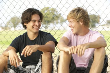 Group Of Teenagers Sitting In Playground clipart