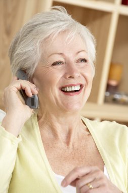 Senior Woman Using Phone At Home clipart