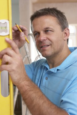 Builder Using Spirit Level On Wall clipart