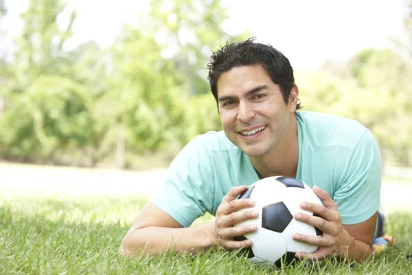 Porträtt av ung man i parken med fotboll — Stockfoto