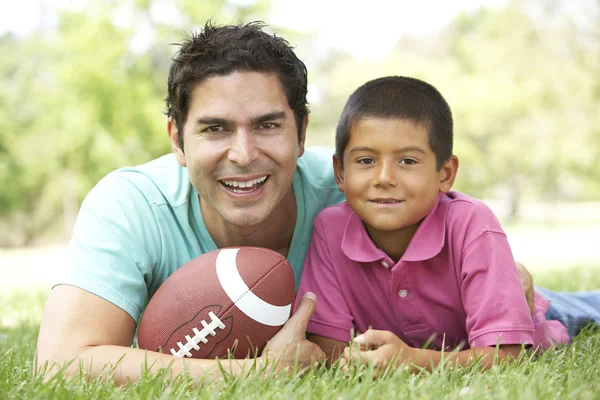Vader en zoon in park met Amerikaans voetbal — Stockfoto