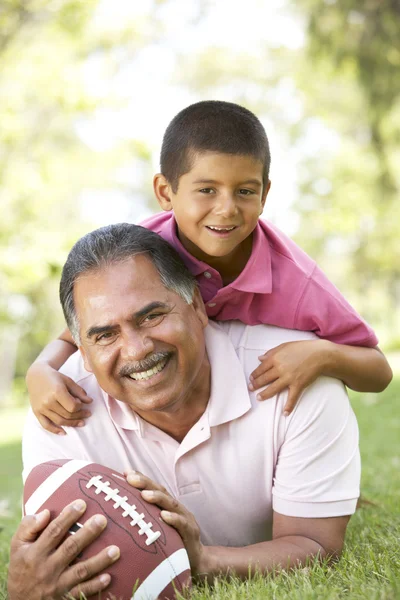 Grootvader met kleinzoon in park met Amerikaans voetbal — Stockfoto