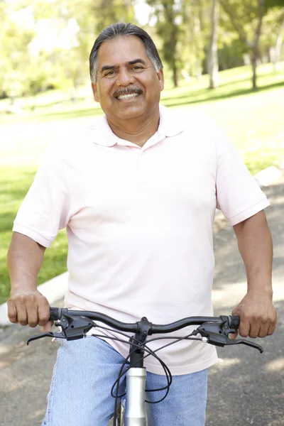 年配の男性人公園で自転車に乗る — ストック写真