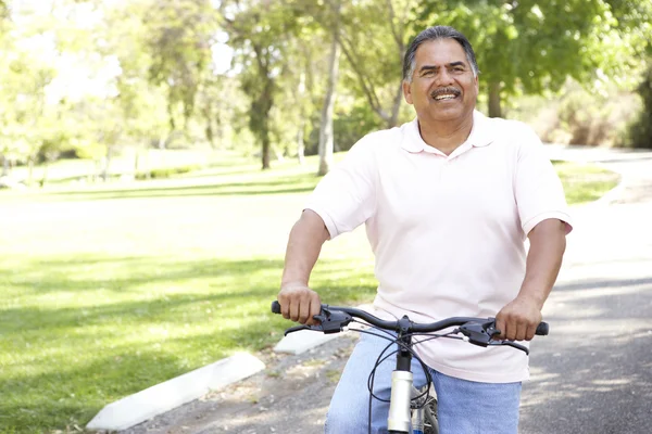 Starszy mężczyzna jazdy rowerem w parku — Zdjęcie stockowe