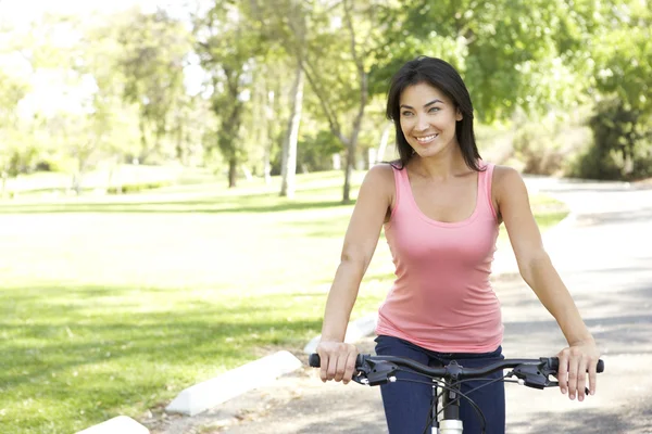 Giovane donna in sella alla bici nel parco — Foto Stock