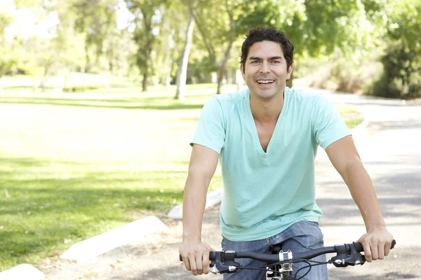 若い男が公園で自転車に乗る — ストック写真