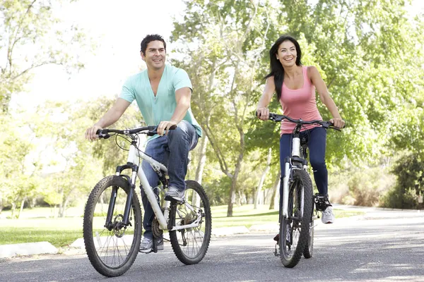 Jovem casal equitação bicicleta no parque — Fotografia de Stock