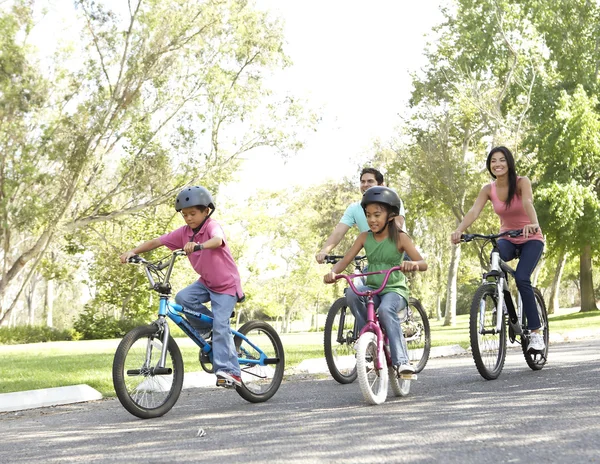 Νεαρή οικογένεια ιππασία ποδήλατα στο πάρκο — Φωτογραφία Αρχείου