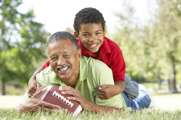 Дедушка с внуком в парке с американским футболом — стоковое фото