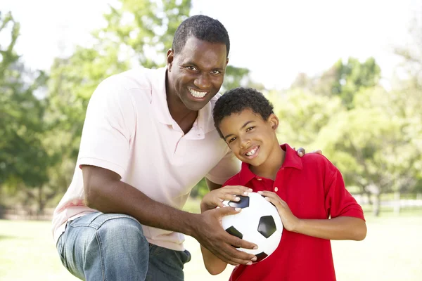 Отец и сын в парке с футболом — стоковое фото