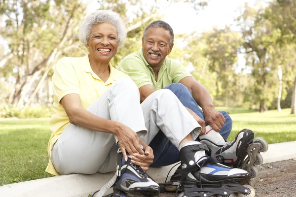 Senior Couple Putting On In Line Skates In Park — Stock Photo, Image