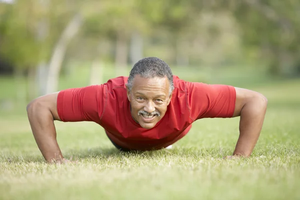 Старший мужчина упражняется в парке — стоковое фото