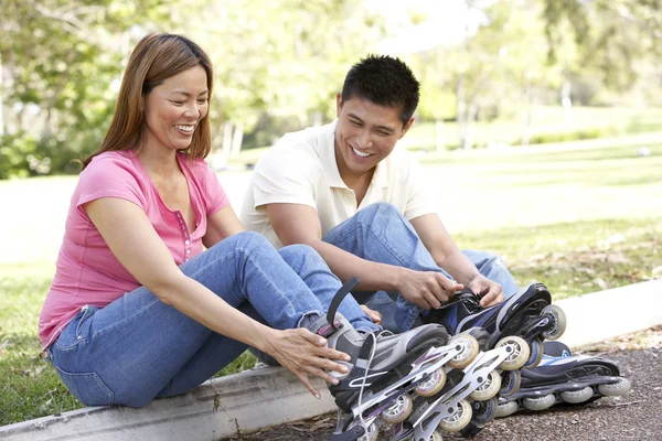 Couple Putting On In Line Skates In Park — Stock Photo, Image