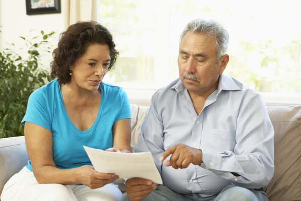Пара пожилых людей изучает финансовый документ дома — стоковое фото