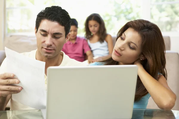 Parents utilisant un ordinateur portable à la maison — Photo