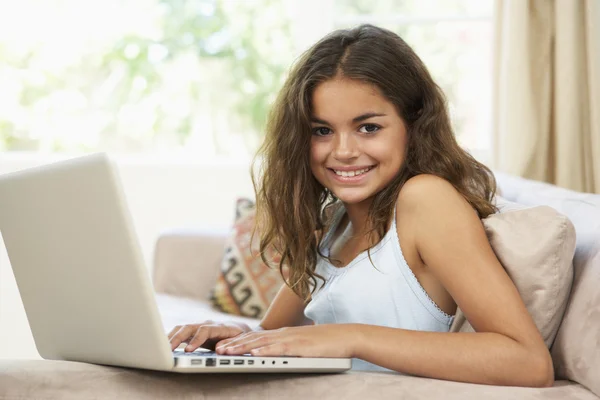 Νεαρό κορίτσι που χρησιμοποιεί φορητό υπολογιστή στο σπίτι — Φωτογραφία Αρχείου