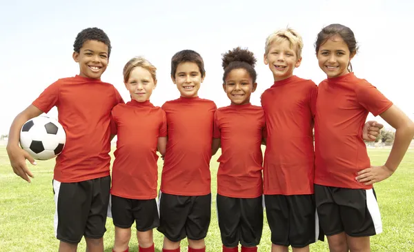Jovens meninos e meninas na equipe de futebol — Fotografia de Stock