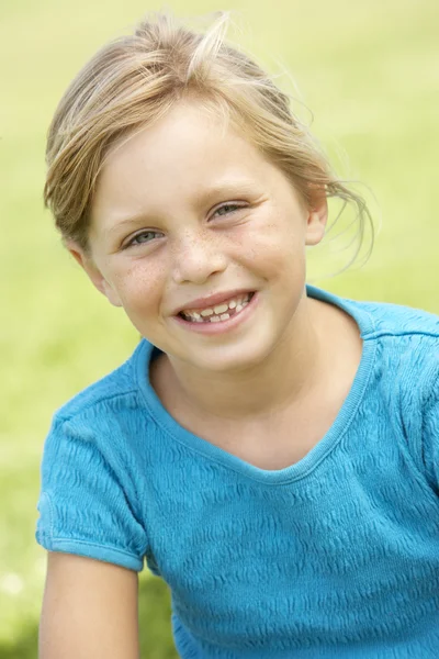 Portrét mladé dívky, sedící v parku — Stock fotografie