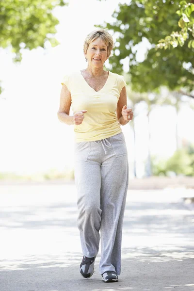 Seniorin joggt im Park — Stockfoto
