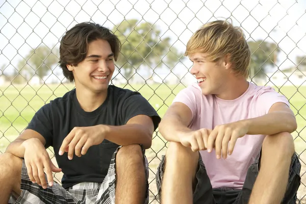 Groupe d'adolescents assis dans une aire de jeux — Photo