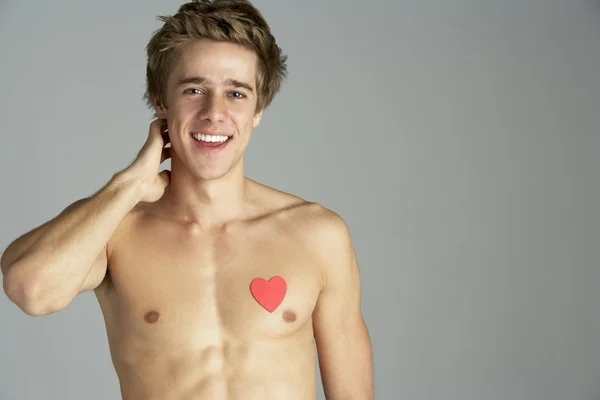Kalp şeklinde simgesi olan yarı çıplak genç adam — Stok fotoğraf